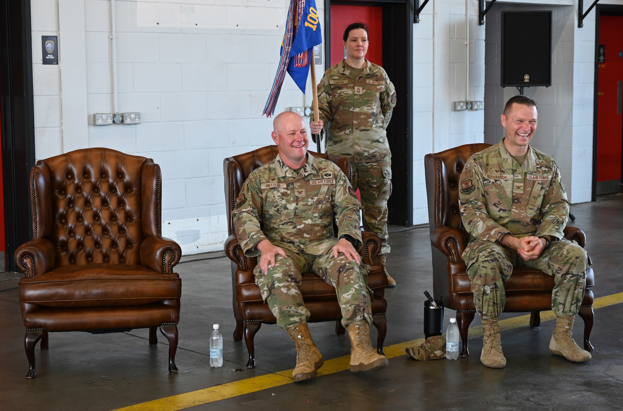 U.S. Air Force Col. Scott Metzler, left, outgoing 100th Mission Support Group commander, and Col. Brandon Bernardoni, incoming 100th MSG commander, laugh at comments made by Col. Steven Byrum, 100th Air Refueling Wing commander and presiding officer, during a change of command at RAF Mildenhall, England, June 26, 2026. Metzler has departed for Robins Air Force Base, Ga., in his new role as the Air Force Reserve Command A6. The change of command ceremony is a time-honored tradition in which one officer relinquishes command and passes it to another. (U.S. Air Force photo by Karen Abeyasekere)
