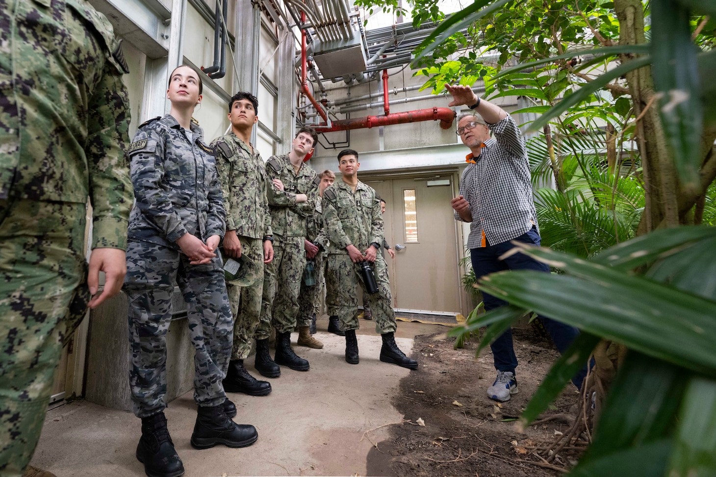 Allen O’Hara, facility manager for the U.S. Naval Research Laboratory's (NRL) Laboratory for Autonomous Systems Research (LASR), leads midshipmen from the U.S. Naval Academy Physics Club on a tour of NRL’s Tropical High Bay in Washington, March 25, 2026. The unique facility allows researchers to test new technology against real-world environmental conditions, ensuring naval systems are reliable and ready for deployment. (U.S. Navy photo by Sarah Peterson) RELEASED