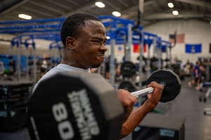 U.S. Air Force Senior Airman Austin Mwandoe, financial operations technician assigned to the 316th Comptroller Squadron, performs an arm curl.