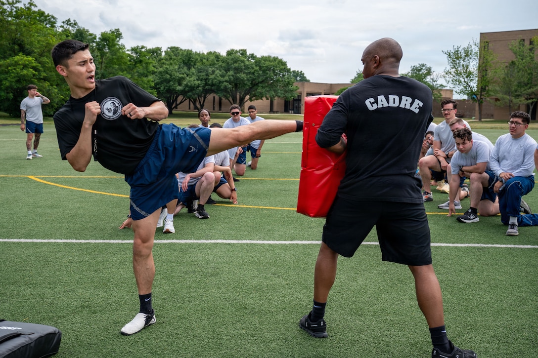 U.S. Air Force Staff Sgt. Brandon Fletcher, left, Airman Leadership School instructor assigned to the 316th Force Support Squadron, and Tech. Sgt. LaMorris McRae, medical information system section chief assigned to the Bolling Medical Squadron, demonstrate proper form during a martial arts lesson.