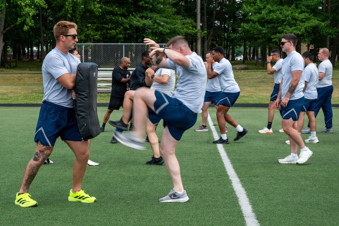 U.S. Airmen with the Donald L. Harlow Airman Leadership School learn martial arts during physical training.