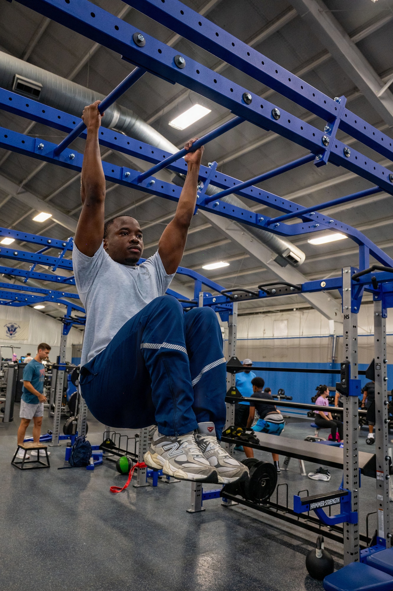 U.S. Air Force Senior Airman Austin Mwandoe, financial operations technician assigned to the 316th Comptroller Squadron, executes high knee tucks.