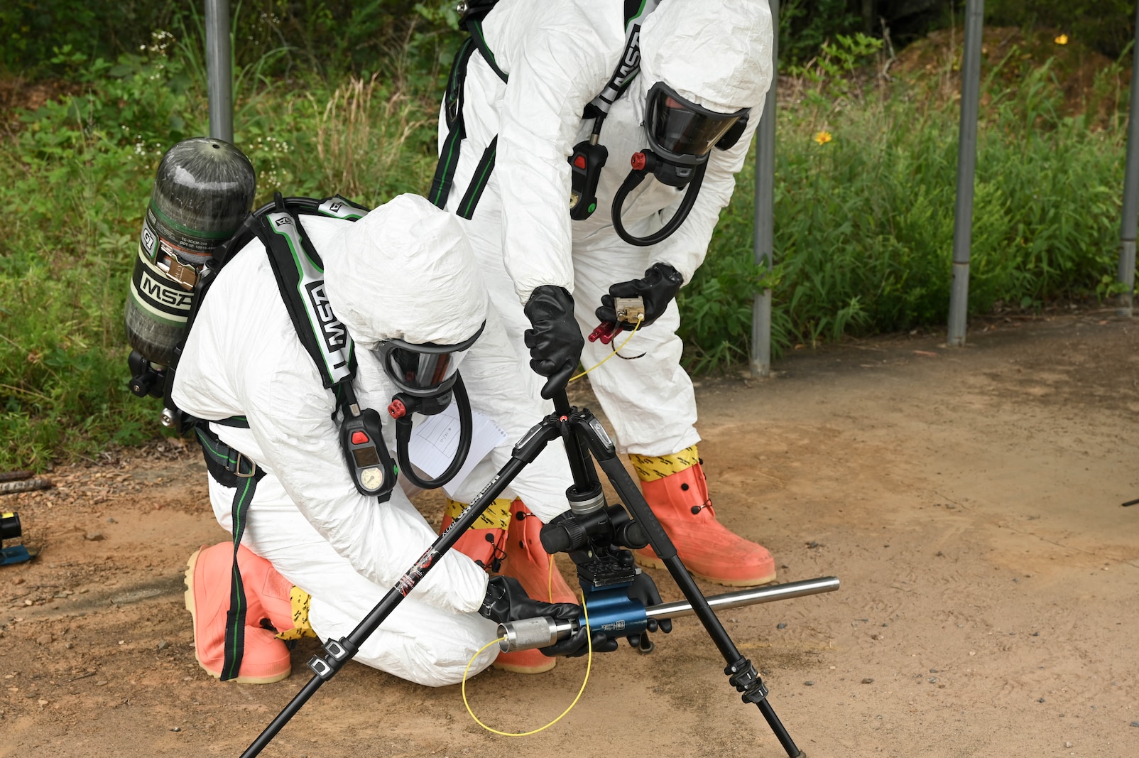 Two men are adjusting a specialized equipment tool