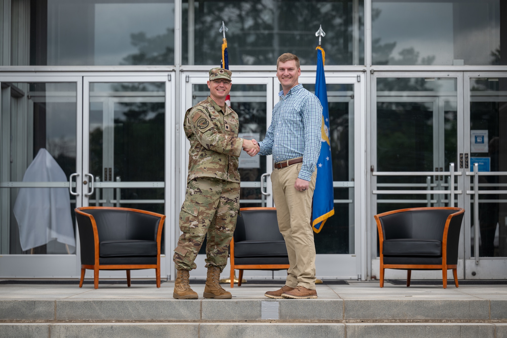 Austin Sisco, Hands-On Science Center executive director, shakes hands with 716th Test Squadron Commander Lt. Col. Jason Thomas during the Arnold Air Force Base Honorary Commanders induction ceremony June 27, 2026, at Arnold AFB, Tenn., headquarters of Arnold Engineering Development Complex. Sisco was selected as the Honorary Commander representing the 716 TS. The Honorary Commanders were inducted during the AEDC 75th anniversary open house celebration at Arnold AFB. (U.S. Air Force photo by Keith Thornburgh)