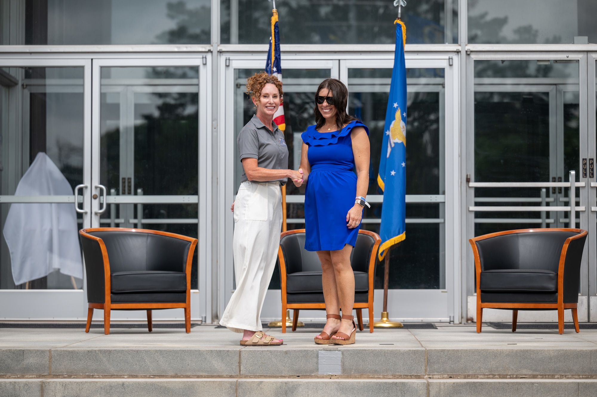 Katy Riddle, Manchester Area Chamber of Commerce executive director, right, shakes hands with Arnold Engineering Development Complex Acquisition Program Manager Kathleen Bajar during the Arnold Air Force Base Honorary Commanders induction ceremony June 27, 2026, at Arnold AFB, Tenn., headquarters of AEDC. Riddle was selected as the Honorary Commander representing the Program Management Division at Arnold AFB. The Honorary Commanders were inducted during the AEDC 75th anniversary open house celebration at Arnold AFB. (U.S. Air Force photo by Keith Thornburgh)