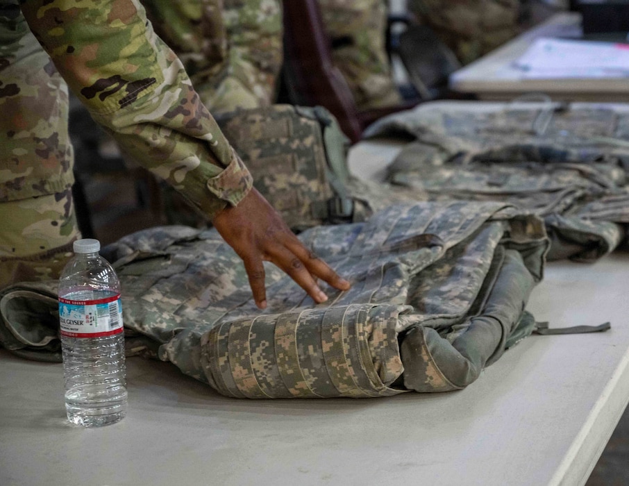 Airman points at equipment.