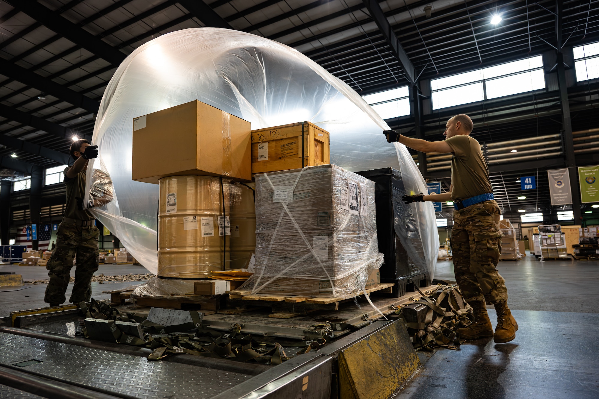 U.S. Air Force Airmen assigned to the 436th Aerial Port Squadron (APS) and the 87th APS work together to cover a pallet in plastic before shipment on Dover Air Force Base, Delaware, June 24, 2026.