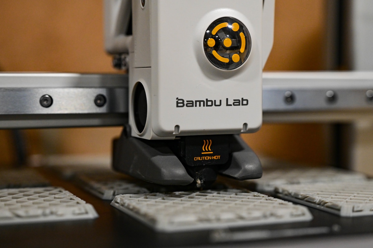 A 3D printing machine prints square layers of filament.