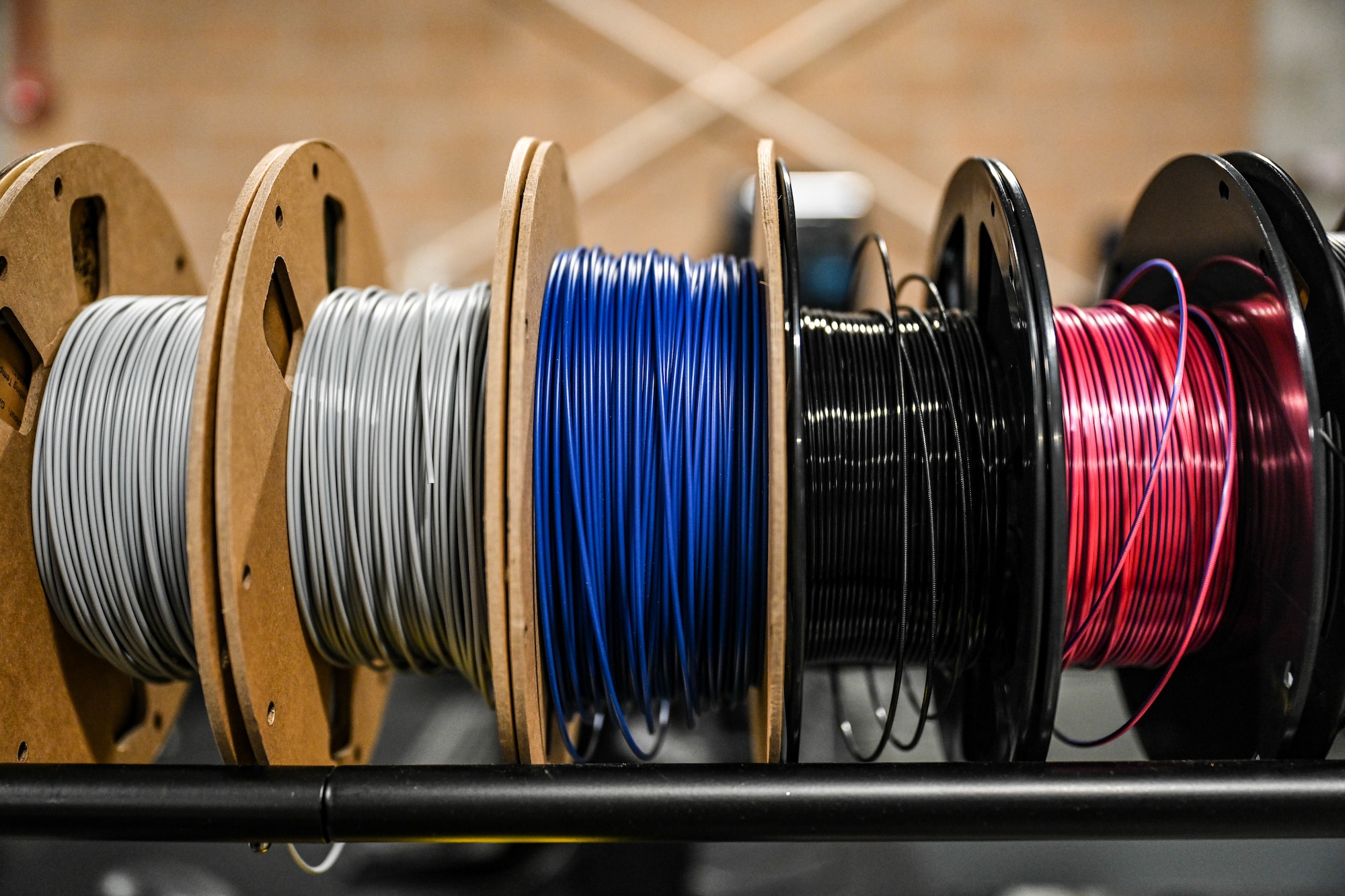 A roll of multicolor 3D printing filaments sit in a row.