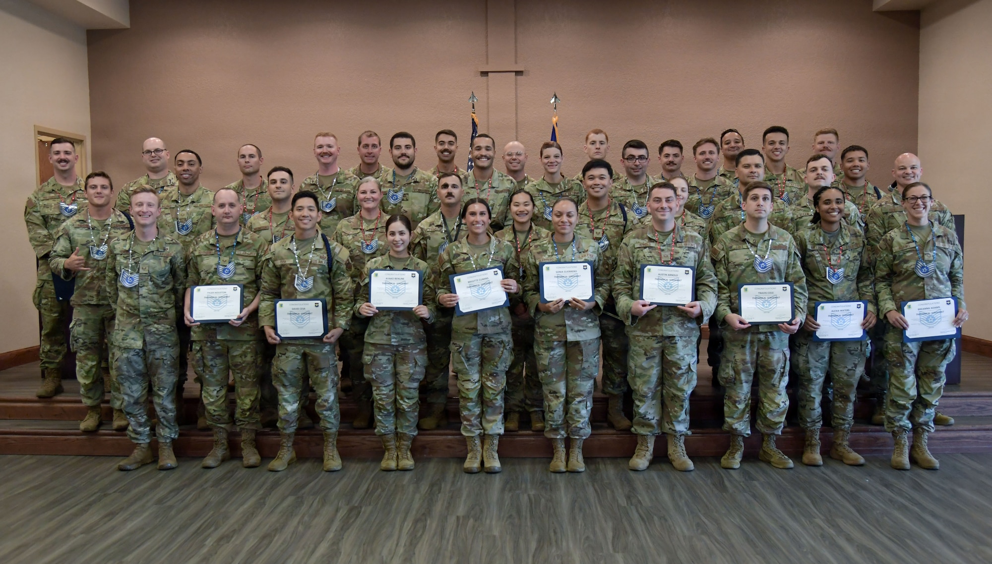 A group of people wearing U.S. Air Force military uniforms pose for a group photo.