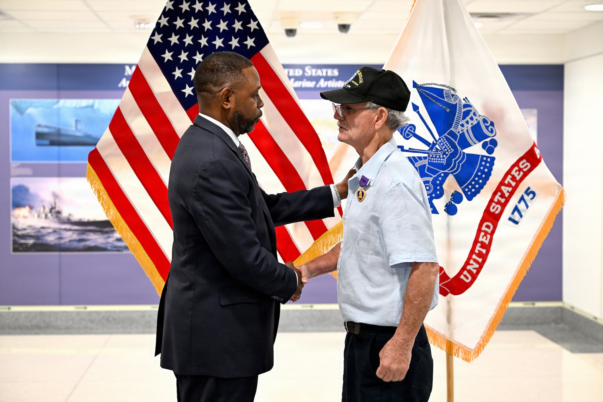 Retired Major General and Army Reserve Ambassador Phillip Churn Sr. presents Specialist Fourth Class Raymond Steven Williams with a Purple Heart medal and citation during a ceremony at the Pentagon.