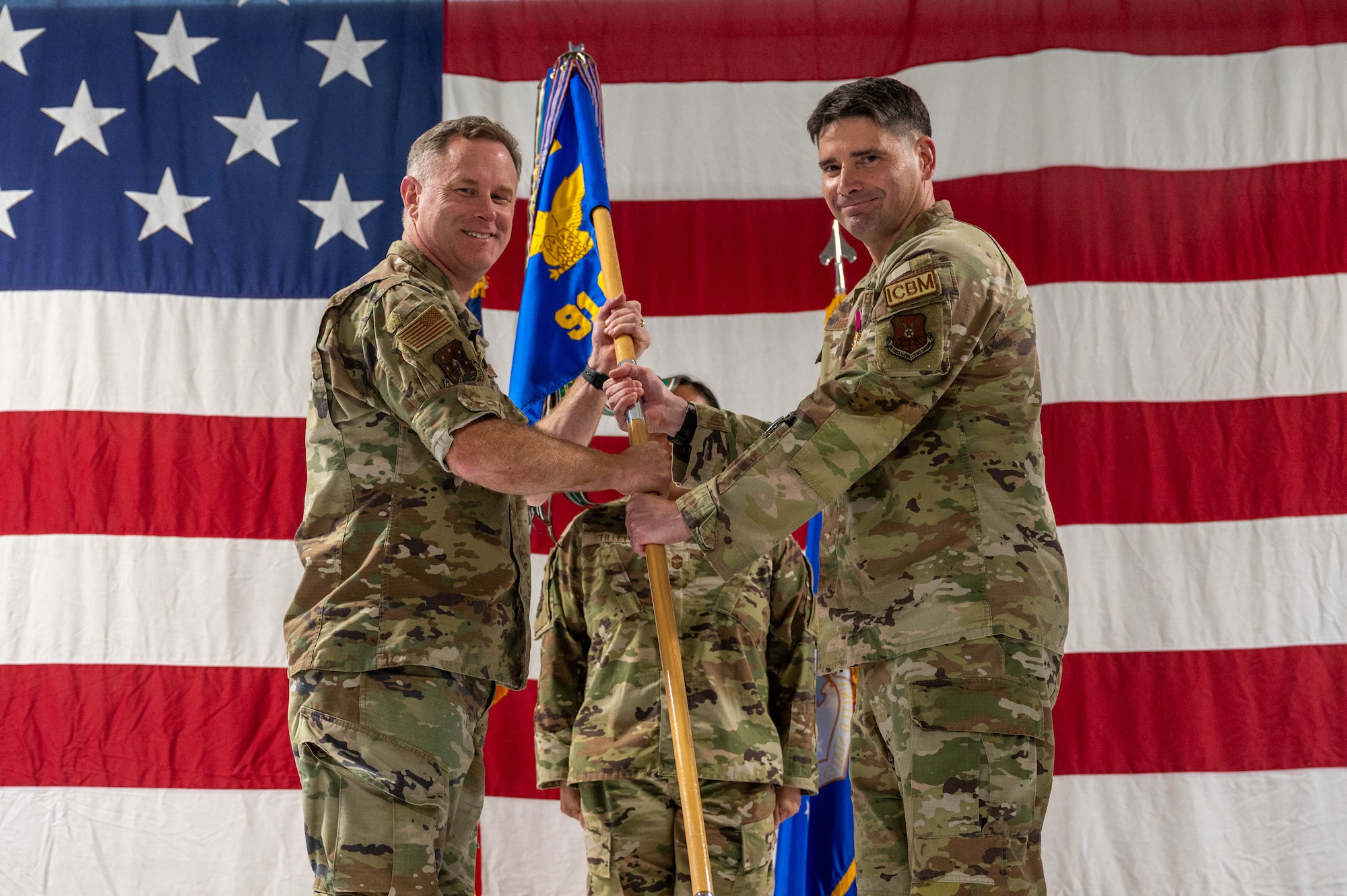 U.S. Air Force Col. Jimmy Schlabach, 91st Missile Wing commander (left), receives the guidon from Col. Michael Suden, 91st Operations Group outgoing commander, during a change of command ceremony at Minot Air Force Base, North Dakota, June 24, 2026.