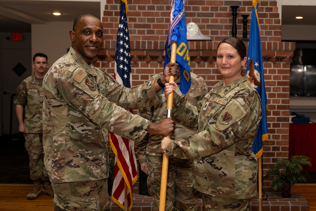 A person passing a guidon to another