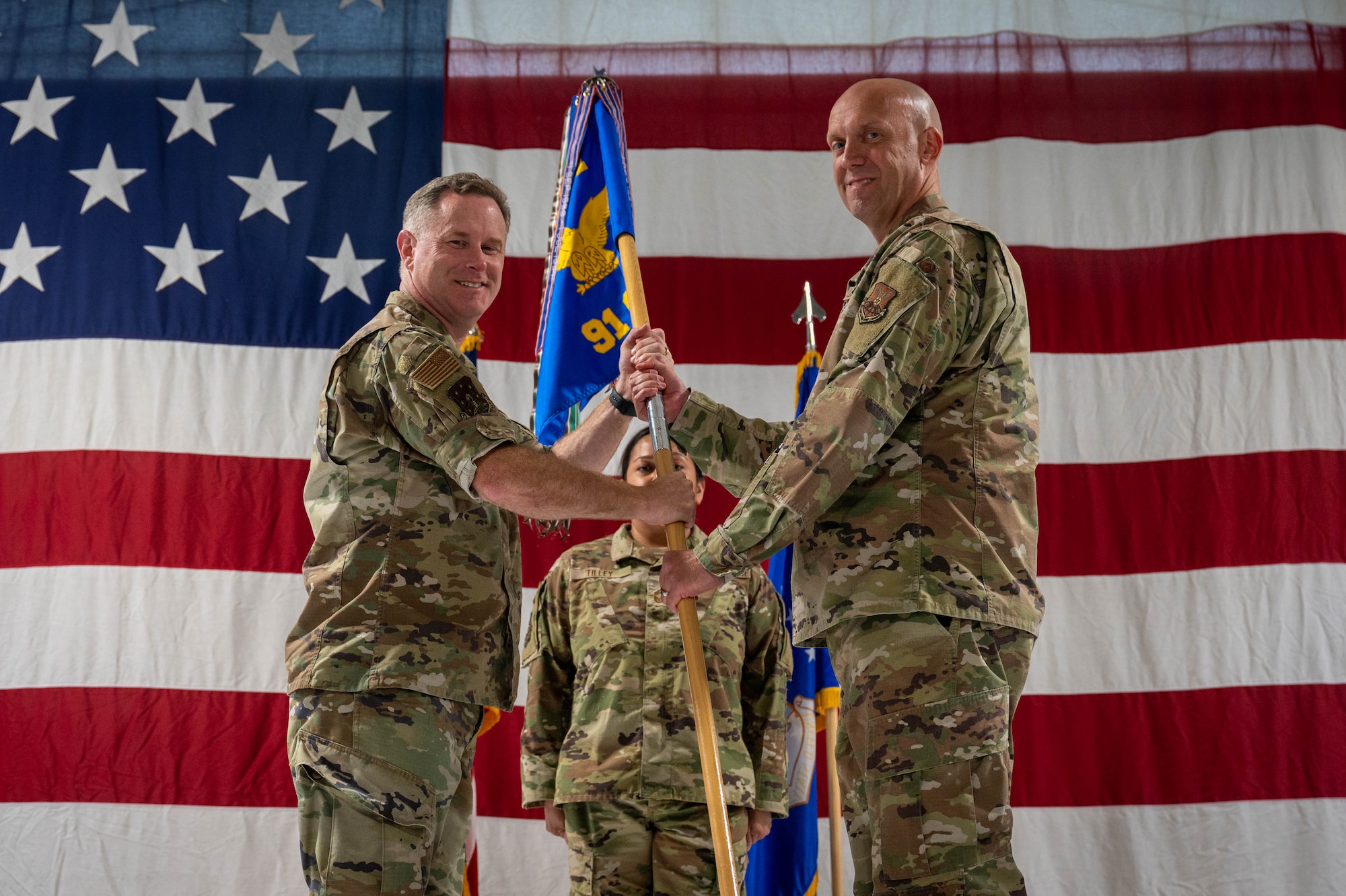 U.S. Air Force Col. Jimmy Schlabach, 91st Missile Wing commander (left), relinquishes the guidon to Col. Daniel Shimonsky, 91st Operations Group incoming commander, during a change of command ceremony at Minot Air Force Base, North Dakota, June 24, 2026.