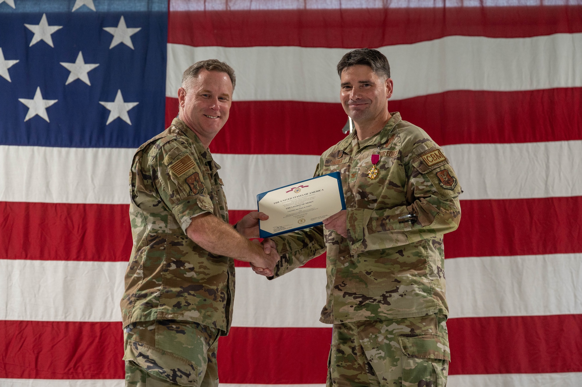 U.S. Air Force Col. Jimmy Schlabach, 91st Missile Wing commander (left), presents the Legion of Merit to Col. Michael Suden, 91st Operations Group outgoing commander, during a change of command ceremony at Minot Air Force Base, North Dakota, June 24, 2026.