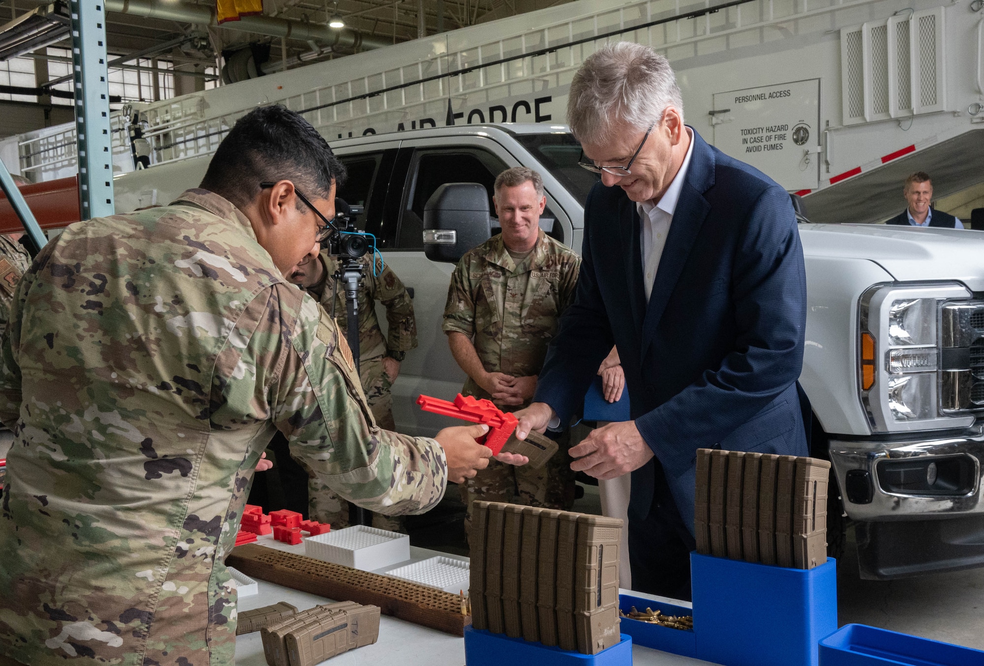 U.S. Air Force Tech. Sgt. Kelvin Moreno, 91st Missile Wing Atomic Spark innovation co-director, shows Secretary of the Air Force Troy Meink a 3-D printed firearm magazine loader during a visit at Minot Air Force Base, North Dakota, June 29, 2026. The modernization of Minot AFB’s legacy Minuteman III infrastructure is one of Meink’s main priorities. Minot AFB is responsible for 15 missile alert facilities and 150 Minuteman III missiles located across roughly 8,000 square miles. (U.S. Air Force photo by Senior Airman Wesley Davies)