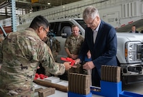 U.S. Air Force Tech. Sgt. Kelvin Moreno, 91st Missile Wing Atomic Spark innovation co-director, shows Secretary of the Air Force Troy Meink a 3-D printed firearm magazine loader during a visit at Minot Air Force Base, North Dakota, June 29, 2026. The modernization of Minot AFB’s legacy Minuteman III infrastructure is one of Meink’s main priorities. Minot AFB is responsible for 15 missile alert facilities and 150 Minuteman III missiles located across roughly 8,000 square miles. (U.S. Air Force photo by Senior Airman Wesley Davies)