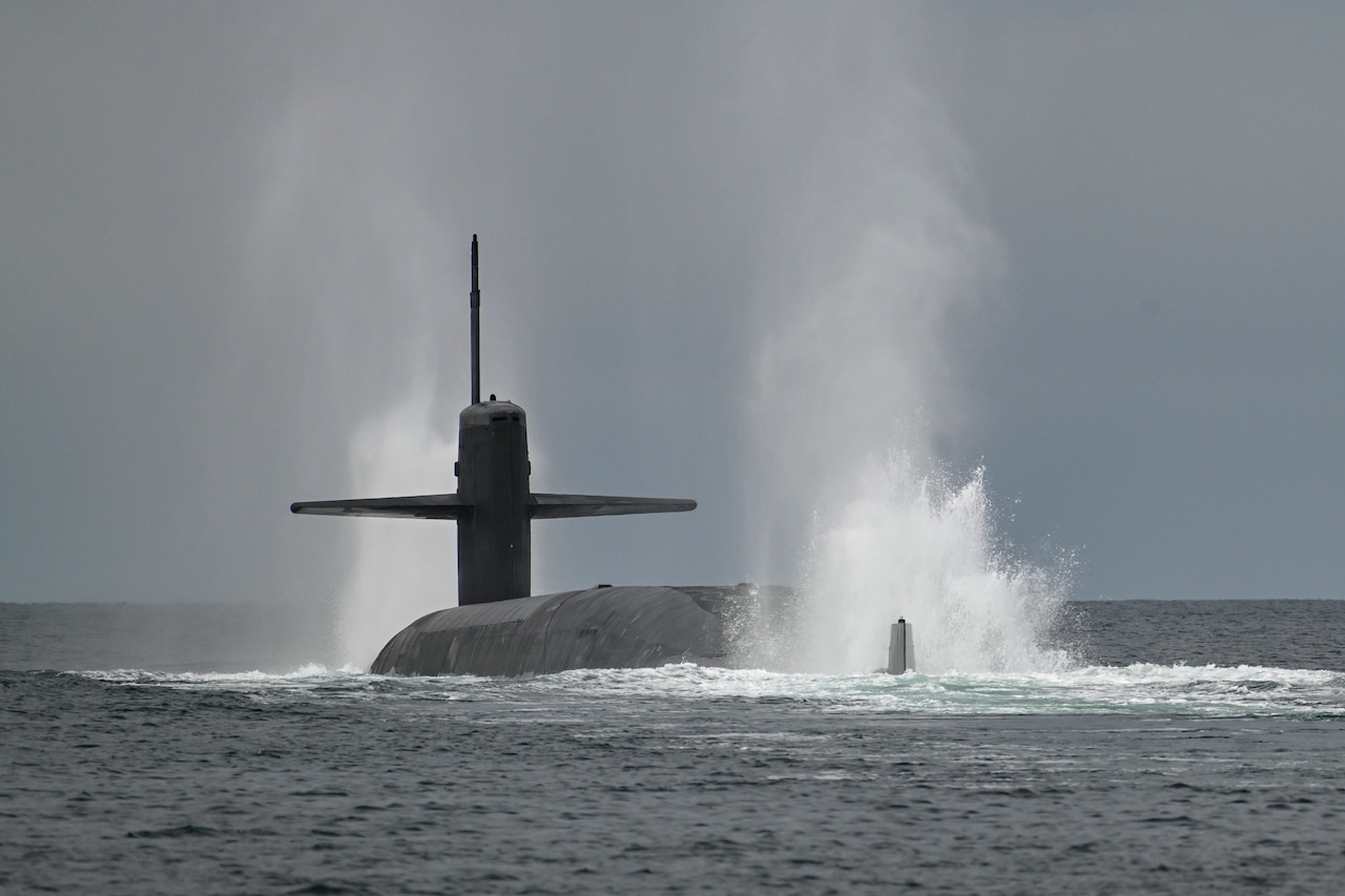 Water splashes upward at the front and back of a submerging submarine.
