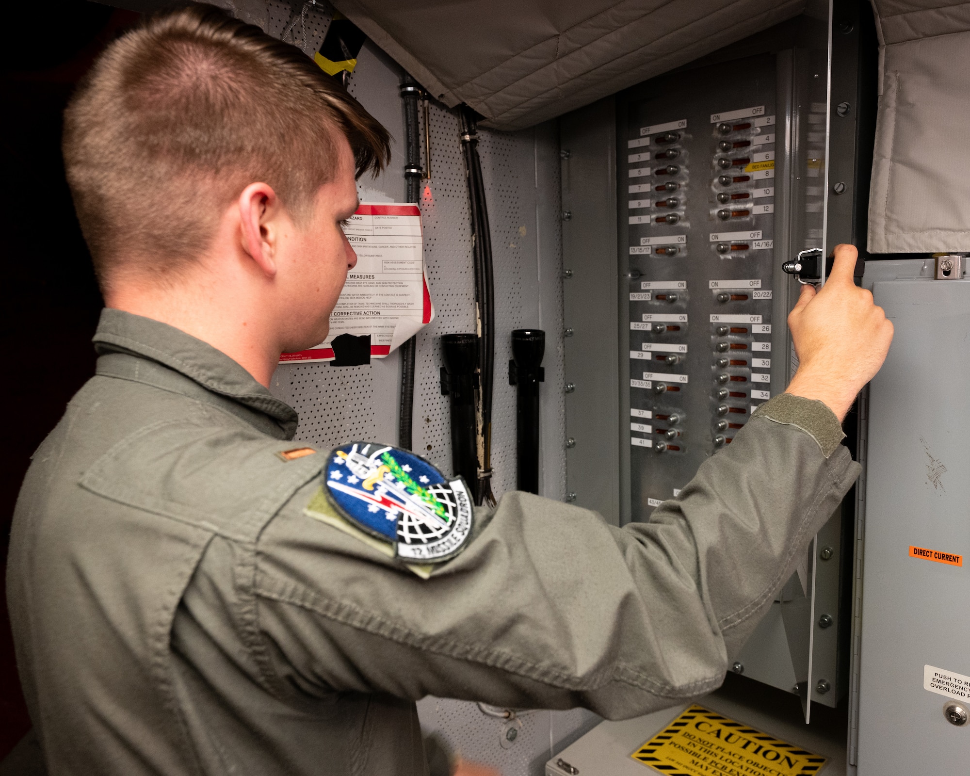 2nd Lt. Brett Kerscher, 12th Missile Squadron missileer, inspects the recently upgraded main circuit breaker panel during changeover at a Minuteman III launch control center in Montana, June 11, 2026. Polychlorinated biphenyls are mixtures of up to 209 individual chlorinated compounds, with no known natural source — they are entirely man-made — so removing original materials eliminates the exposure pathway. (U.S. Air Force photo by Tech. Sgt. Aaron Thomasson)