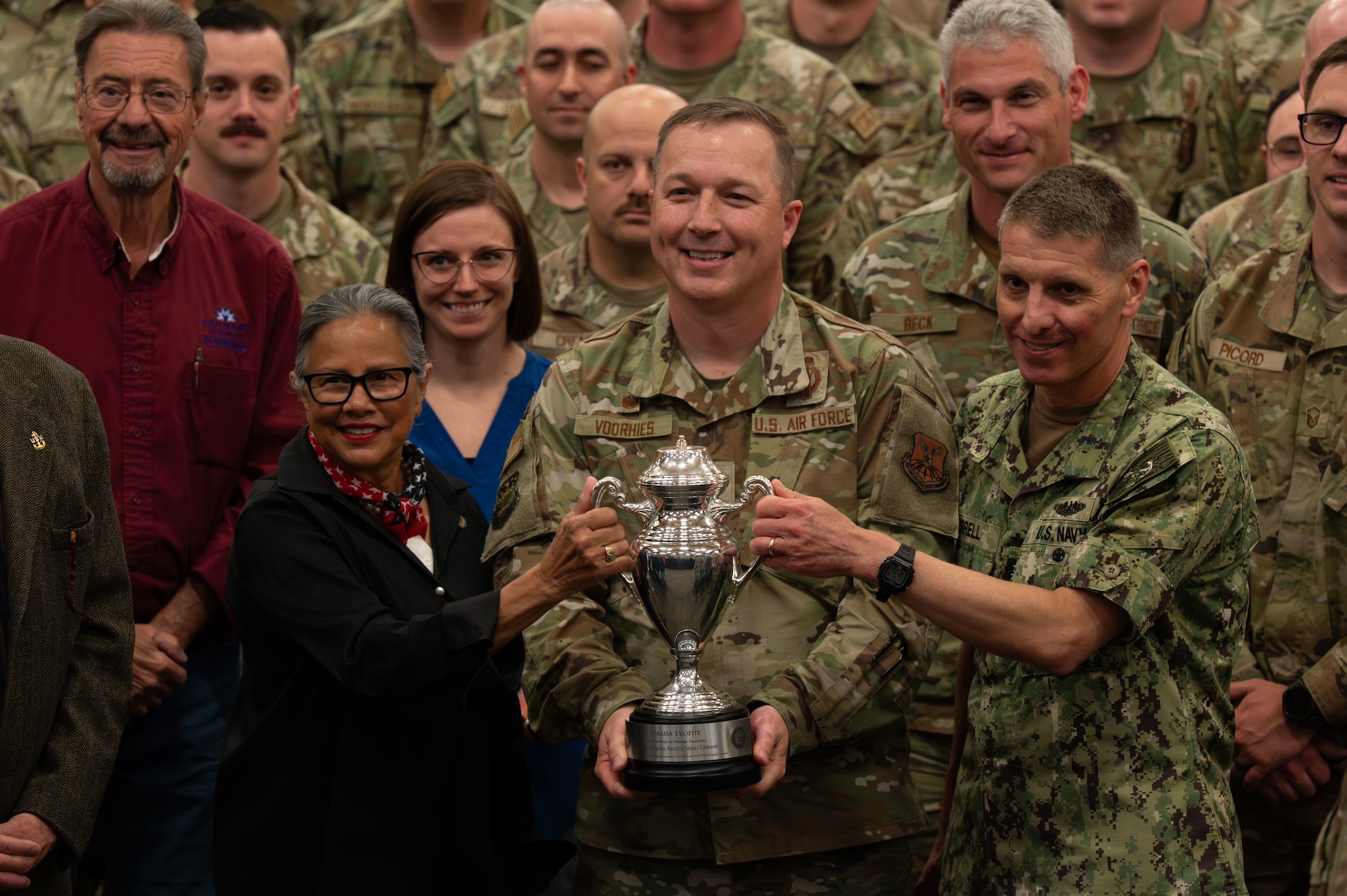 U.S. Navy Adm. Rich Correll, commander of U.S. Strategic Command, right, and Nebraska State Sen. Rita Sanders, a member of the Strategic Command Consultation Committee (SCCC), left, hold the 2025 Omaha Trophy alongside U.S. Air Force Col. Daniel Voorhies, 341st Missile Wing commander, at Malmstrom Air Force Base, Montana, June 18, 2026. The Omaha Trophy has been awarded annually since 1971 by the SCCC, a historic group of Omaha-based civic leaders focused on supporting USSTRATCOM’s mission and people and is regarded as the highest honor bestowed upon a nuclear enterprise unit by a civilian organization. (U.S. Air Force photo by Airman 1st Class Ethan Wilson)