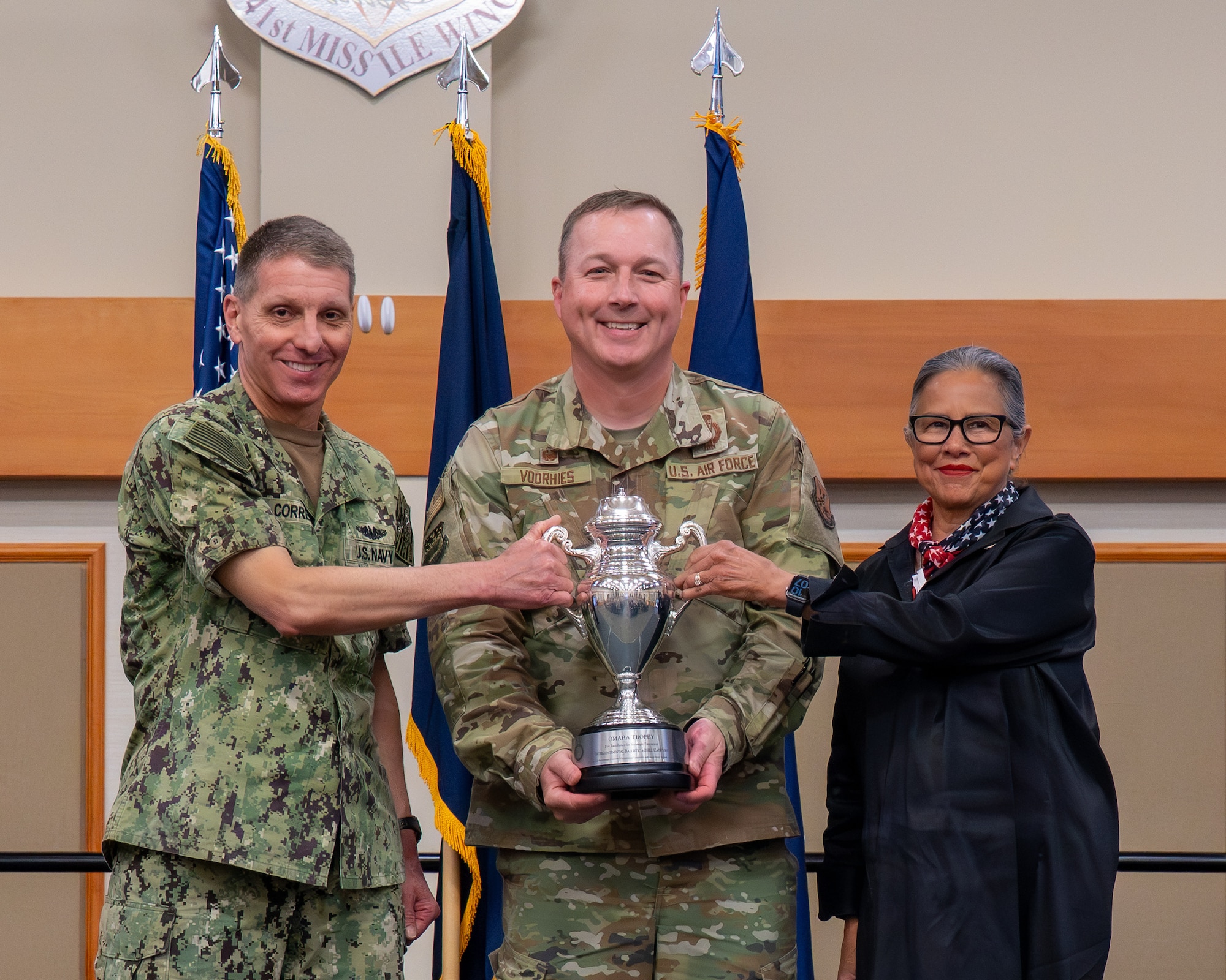 U.S. Navy Adm. Rich Correll, commander, U.S. Strategic Command, left, U.S. Air Force Col. Daniel Voorhies, 341st Missile Wing (MW) commander, and Nebraska State Sen. Rita Sanders, a member of the Strategic Command Consultation Committee (SCCC), pose with the 2025 Omaha Trophy at Malmstrom Air Force Base, Montana, June 18, 2026. The 341st MW competes against the Air Force's two other missile wings and has won the trophy eight times since 2007. (U.S. Air Force photo by Tech. Sgt. Aaron Thomasson)