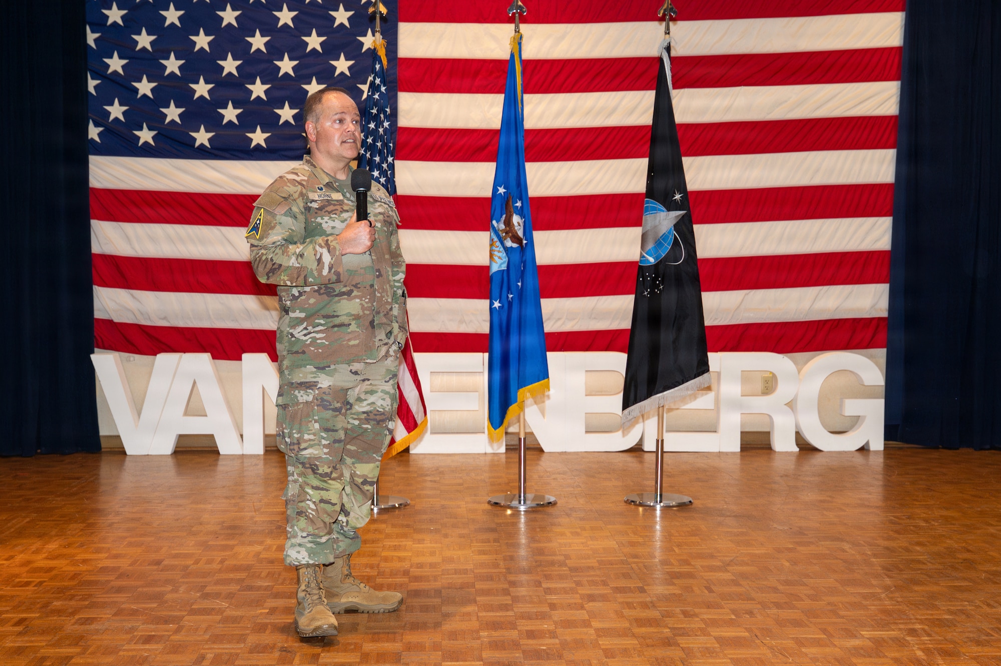 A person stands and speaks into a microphone