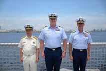 From left to right, Japan Coast Guard Vice Commandant for Operations, Hiroaki Kanosue; U.S. Coast Guard Capt. Brian Whisler, commanding officer of Legend-class cutter USCGC Midgett (WMSL 757); U.S. Coast Guard Vice Adm. Joseph Buzzella, commander, Pacific Area; pose on the flight deck of Midgett during a visit to Yokohama, Japan, June 19, 2026.