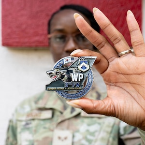 Airman holds coin.