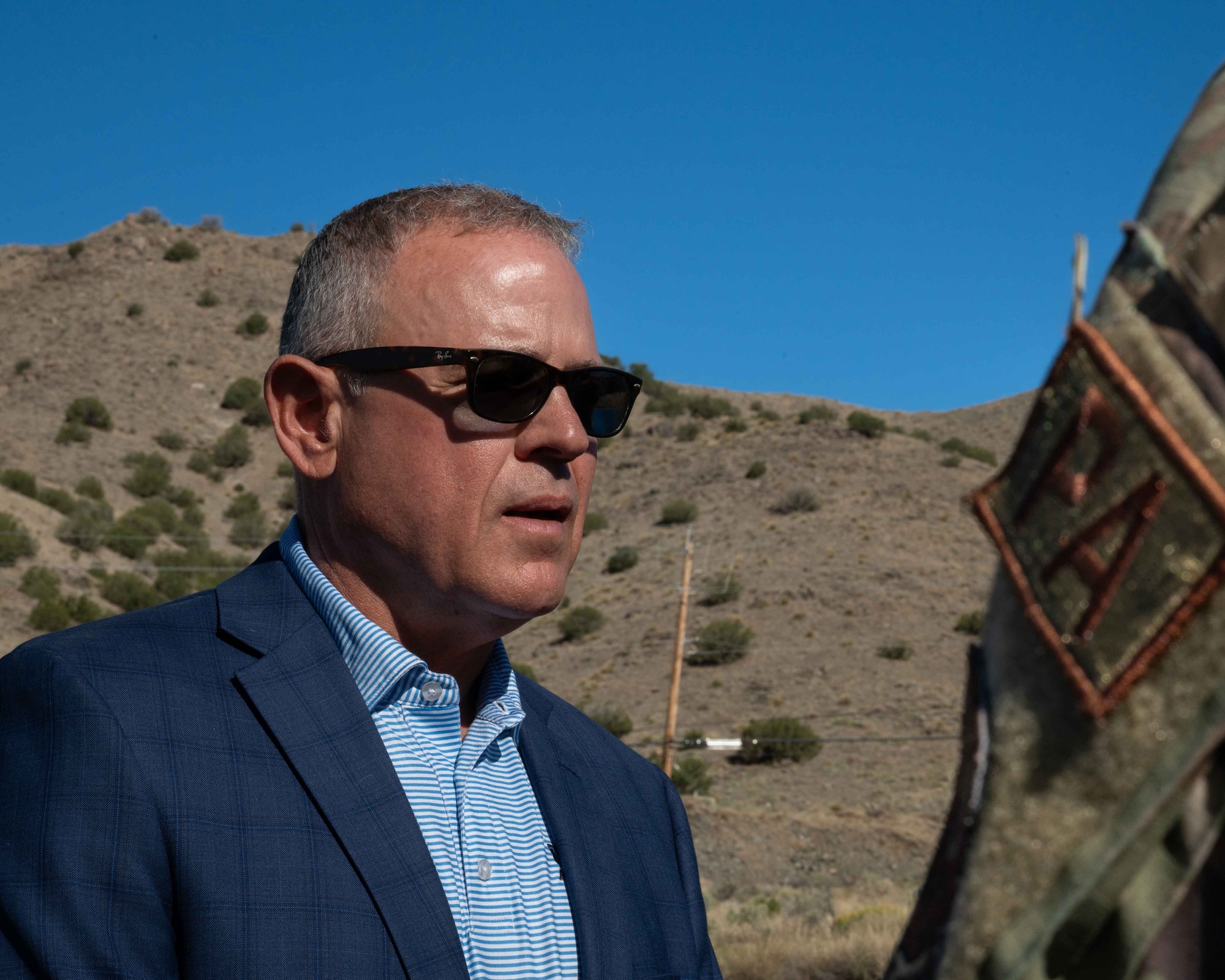 Retired U.S. Navy Cmdr. Douglas Murphy speaking to a Public Affairs Airman in front of the Manzano Mountains at Kirtland Air Force Base, New Mexico, June 26, 2026.