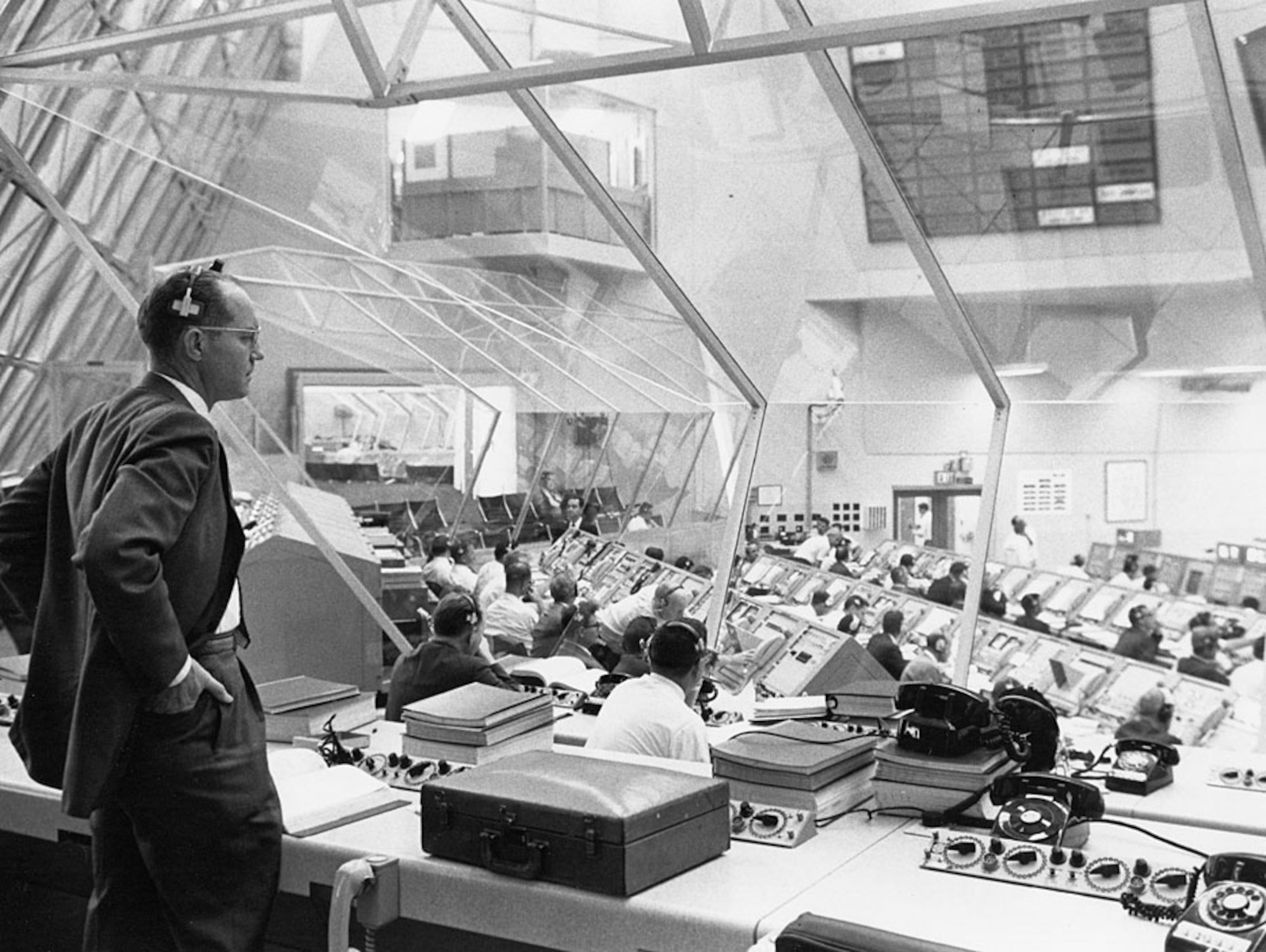 A man stands over computers from 1969 while surveying the Spacecraft center in Houston.