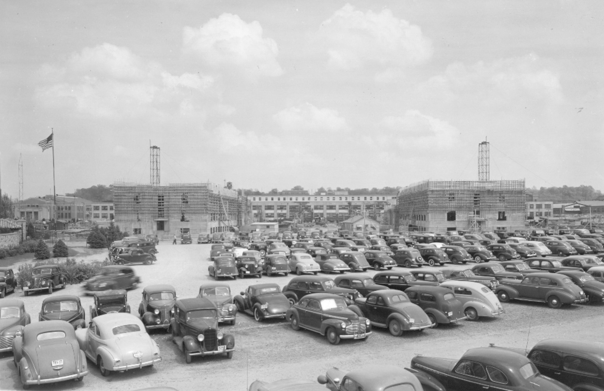 Cars parked in front of buildings that are under construction