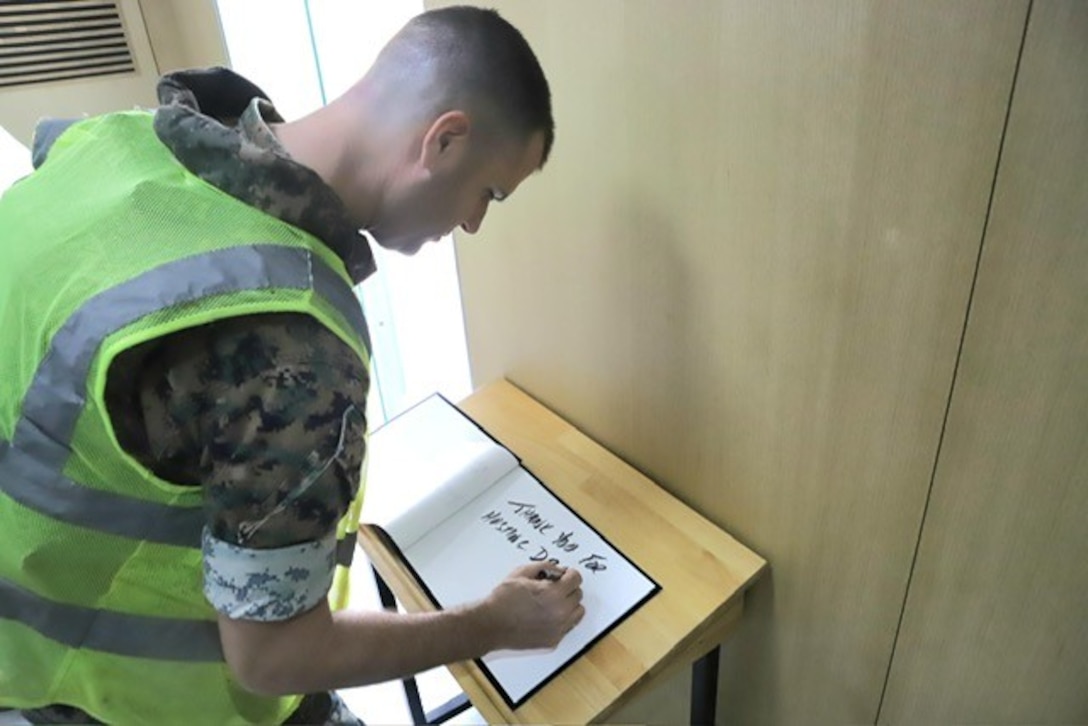 An individual signs a book.