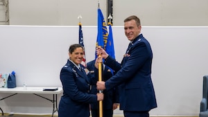 Col. Paola Ondina passes the guidon to Lt. Col. James Lancaster during the GXF change of command ceremony.