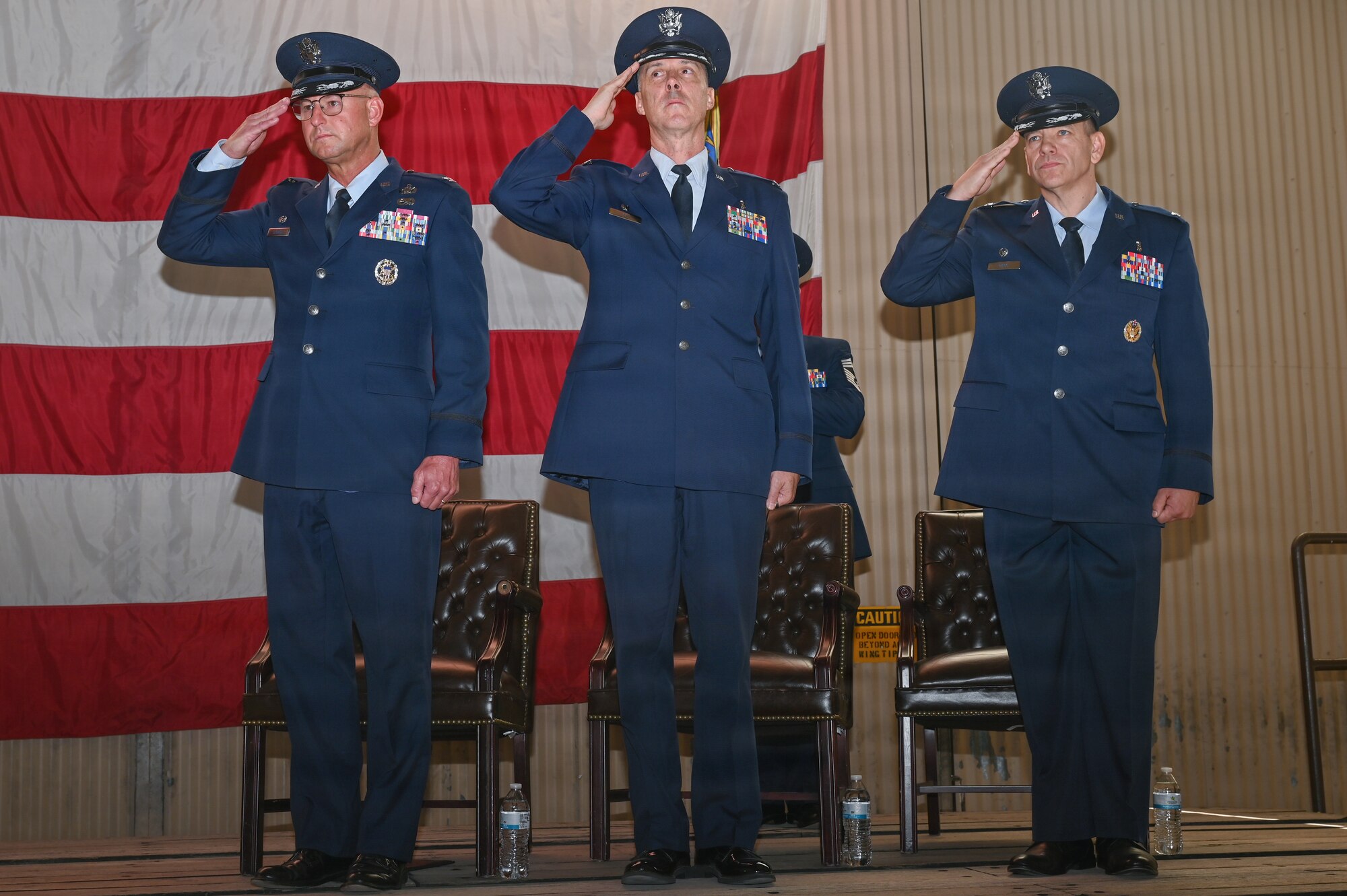 Left to right, U.S. Air Force Col. Justin D. Secrest, 377th Air Base Wing and installation commander, Col. Steven M. Fox, outgoing Kirtland Medical Group commander, and Col. Cody J. Hess, incoming Kirtland Medical Group commander, salute during the singing of the national anthem at the Kirtland Medical Group change of command ceremony at Kirtland Air Force Base.