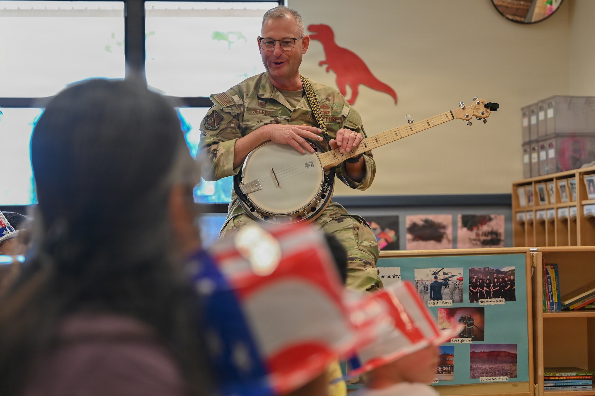 U.S. Air Force Col. Justin D. Secrest, 377 Air Base Wing and installation commander, plays the banjo for children at the Maxwell Child Development Center at Kirtland Air Force Base.