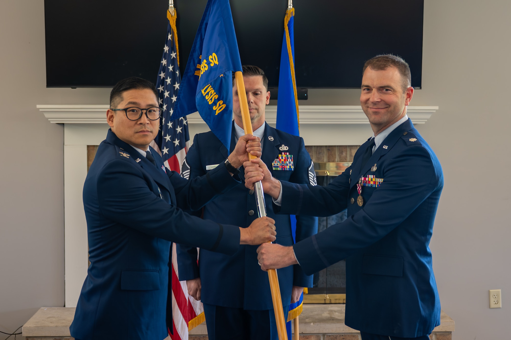 Lt. Col. Evan Carlson, right, Electromagnetic Systems Analysis Squadron outgoing commander, relinquishes command to Col. Gene Noh, Forces and Technologies Intelligence Group commander, during an change of command ceremony at Wright-Patterson Air Force Base, Ohio, June 24, 2026. The passing of the guidon is a military tradition signifying the formal transfer of authority and responsibility from the outgoing commander to the presiding officer. (U.S. Air Force photo by Staff Sgt. Kristof J. Rixmann)