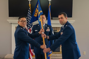 Lt. Col. Lloyd Hutton receives the guidon from Col. Gene Noh, Forces and Technologies Intelligence Group commander, as he takes command of the Electromagnetic Systems Analysis Squadron at Wright-Patterson Air Force Base, Ohio, June 24, 2026. The passing of the guidon is a military tradition signifying the formal transfer of authority and responsibility from the outgoing commander to the presiding officer. (U.S. Air Force photo by Staff Sgt. Kristof J. Rixmann)