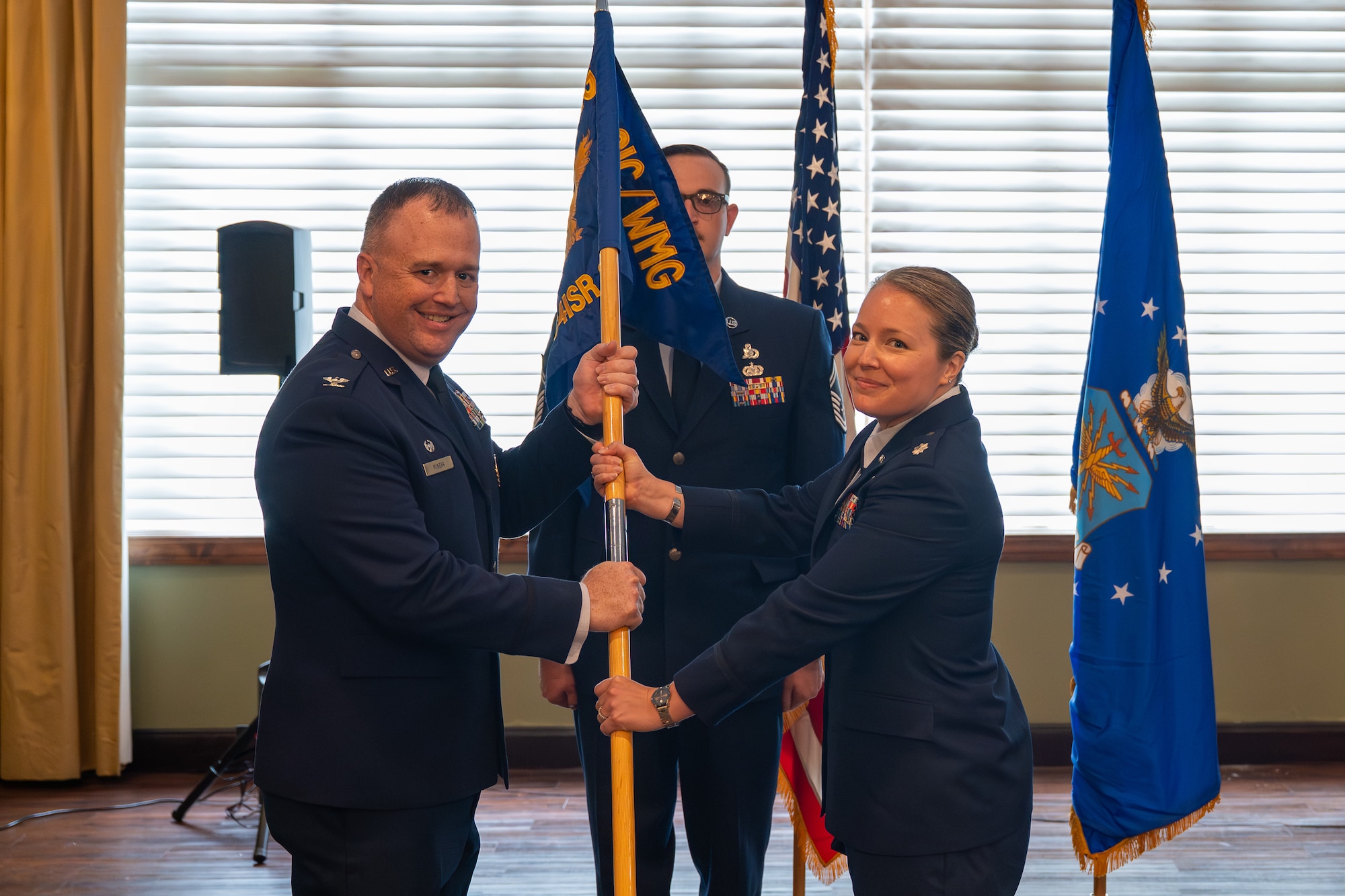 Lt. Col. Cara Treadwell assumes command of the Integrated Command, Control, Communications, Computers, Intelligence, Surveillance, and Reconnaissance Analysis Squadron after receiving the guidon from Col. John M. Minear, Networked Weapons and Modeling Intelligence Group commander, at Wright-Patterson Air Force Base, Ohio, June 29, 2026. The ceremony formally charges Treadwell with the leadership, welfare, and mission readiness of the squadron's personnel. (U.S. Air Force photo by Staff Sgt. Kristof J. Rixmann)