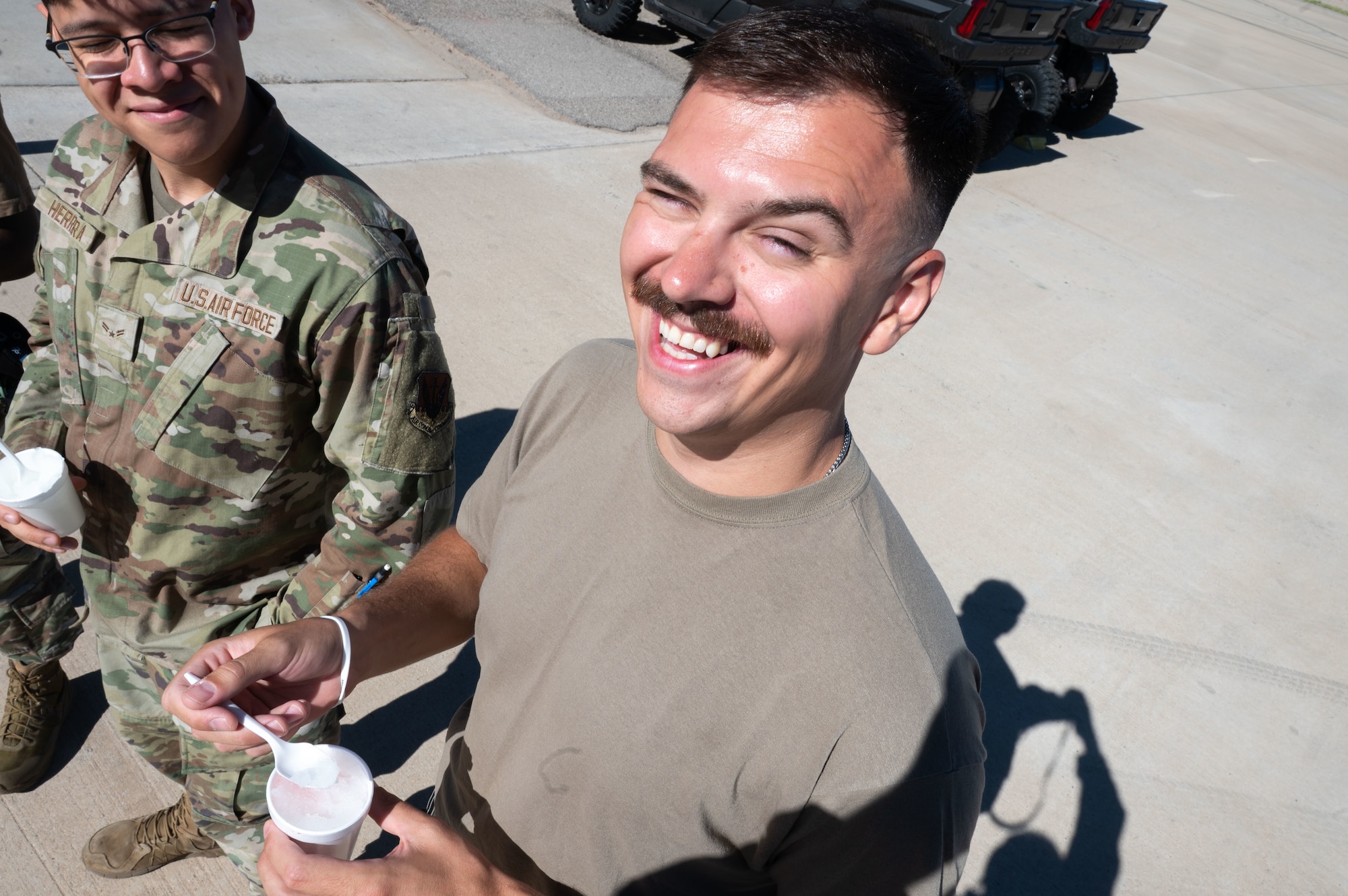 A 55th Rescue Generation Squadron Airman, poses for a photo with shaved ice provided by DM50, the Military Affairs Committee and the First Sergeants Council at Davis-Monthan Air Force Base, Arizona, July 2, 2026. The effort supported the well-being of Airmen working in high temperatures, reinforcing a culture of care and connectedness. (U.S. Air Force photo by Airman 1st Class Jaden Kidd)