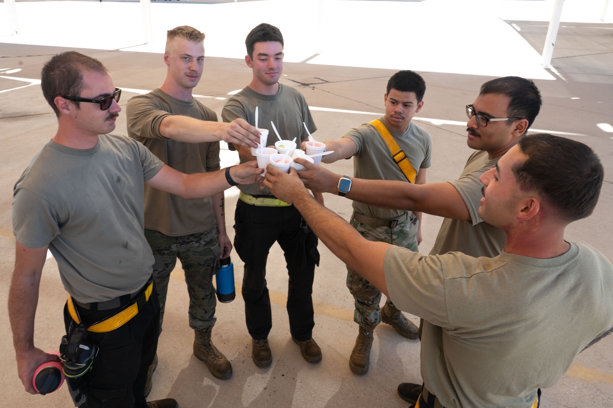U.S. Air Force Airmen from the 357th Fighter Generation Squadron, pose for a photo with shaved ice provided by DM50, the Military Affairs Committee and the First Sergeants Council at Davis-Monthan Air Force Base, Arizona, July 2, 2026. The effort supported the well-being of Airmen working in high temperatures, reinforcing a culture of care and connectedness. (U.S. Air Force photo by Airman 1st Class Jaden Kidd)