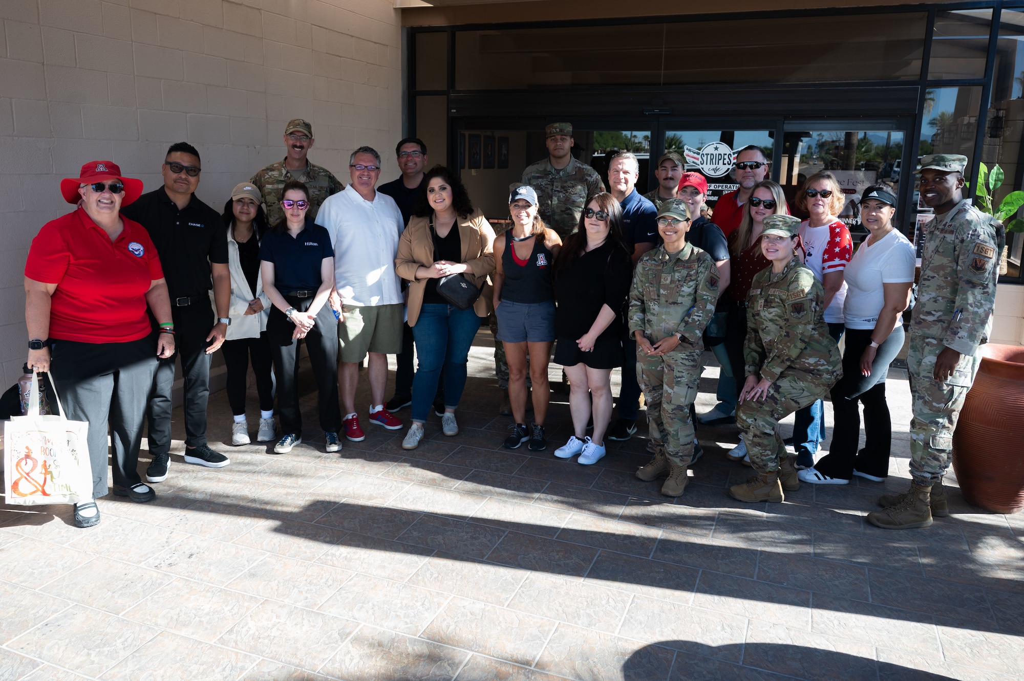 U.S. Air Force Airmen and Military Affairs Committee members pose for a group photo in front of the community center at Davis-Monthan Air Force Base, Arizona, July 2, 2026. DM50 partnered with the MAC and the First Sergeants Council to visit various squadrons and hand out shaved ice, offering a refreshing break from the heat while fostering connection and morale among Airmen. (U.S. Air Force photo by Airman 1st Class Jaden Kidd)