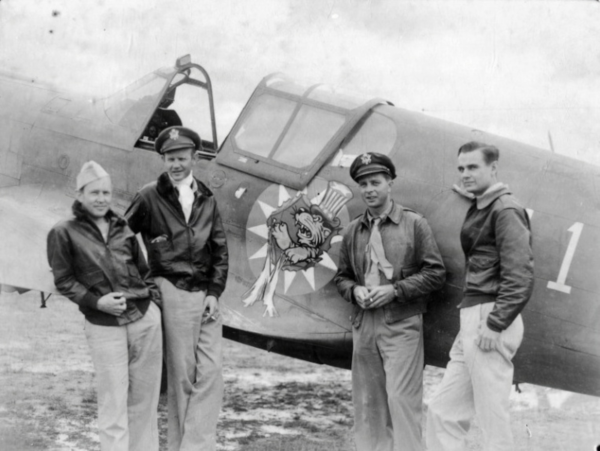U.S. pilots assigned to the 23d Fighter Group pose with a Curtiss P-40 at the flightline in Kunming, China, July 1942.