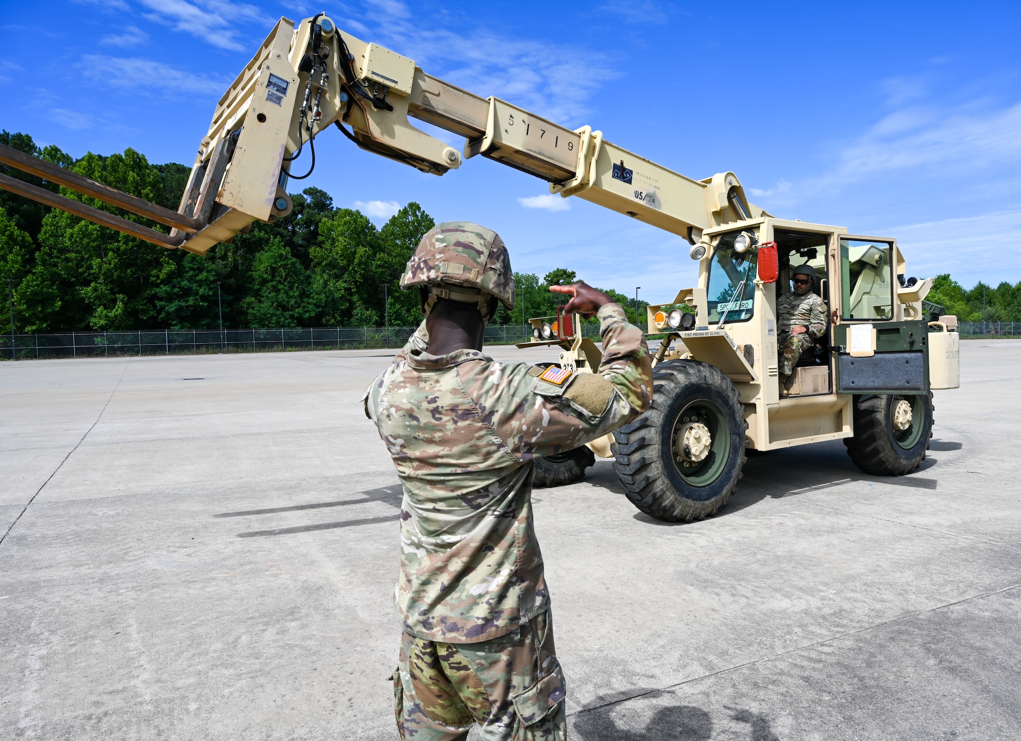 Soldier uses hand signals to train forklift operator. (U.S. Air Force photo by Airman 1st Class Donnell Ramsey)