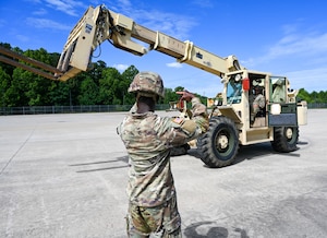 Soldier uses hand signals to train forklift operator. (U.S. Air Force photo by Airman 1st Class Donnell Ramsey)