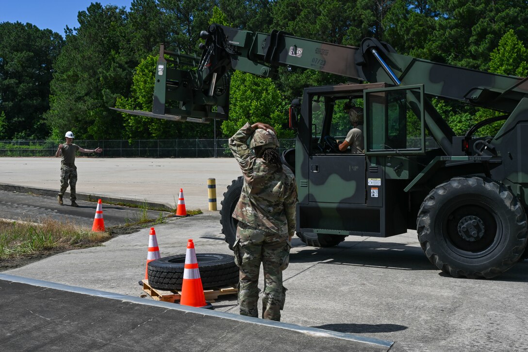Soldiers guide a forklift operator around traffic cones. (U.S. Air Force photo by Airman 1st Class Donnell Ramsey)