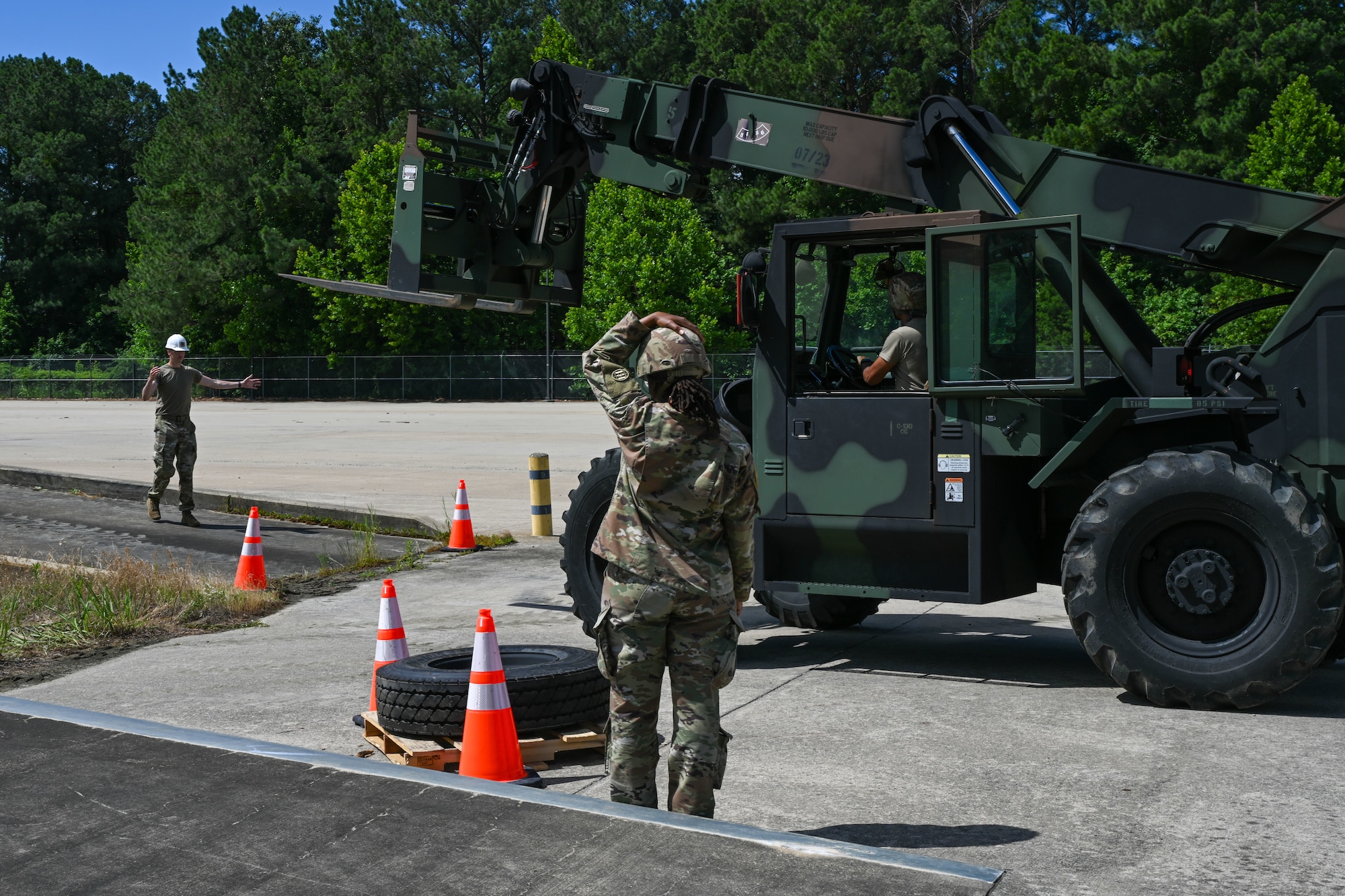 Soldiers guide a forklift operator around traffic cones. (U.S. Air Force photo by Airman 1st Class Donnell Ramsey)