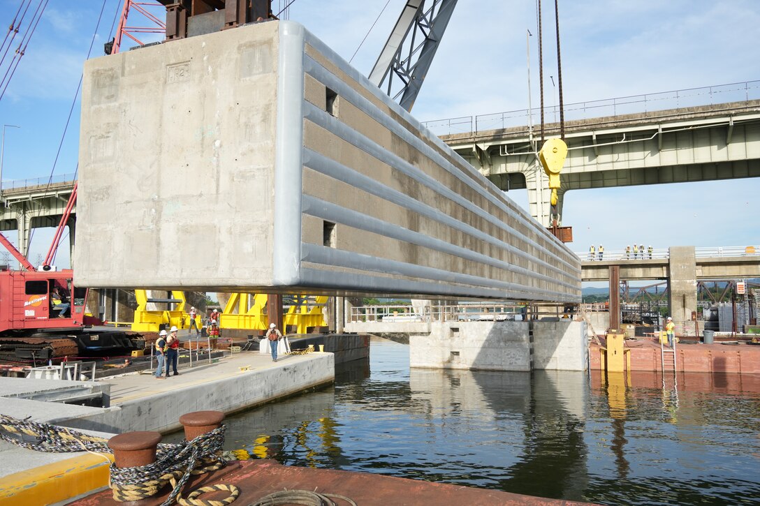 A 420-ton concrete beam is hoisted into position over the Tennessee River during construction of the upstream approach wall for the Chickamauga Lock Replacement Project, June 16, 2026, in Chattanooga, Tenn. The successful placement of these massive beams, guided by contractors on the pier below, marks a significant milestone in the U.S. Army Corps of Engineers' mission to modernize the nation's inland waterways and deliver critical navigation infrastructure. (USACE Photo by Noe Gonzalez)