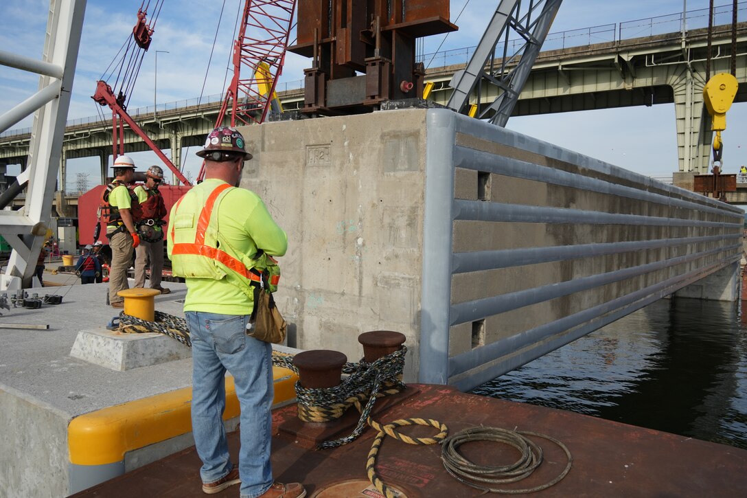 McKinney Salvage LLC, a subcontractor for CJ Mahan Construction Co., operates a heavy-lift derrick crane to guide a 420-ton concrete beam into position for the Chickamauga Lock Replacement Project's upstream approach wall Tuesday, June 16, 2026, on the Tennessee River. The placement marks the first of eight beams installed during this phase of construction for the U.S. Army Corps of Engineers Nashville District, demonstrating the critical engineering partnerships driving forward USACE’s mission to modernize regional waterways and deliver resilient navigation infrastructure for the nation. (USACE Photo by Noe Gonzalez)