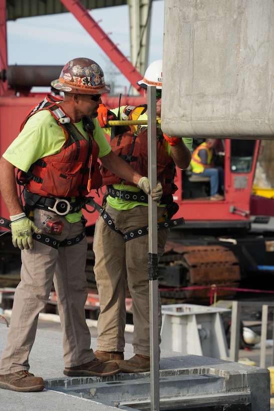 Contractors take precise measurements to ensure a 420-ton concrete beam aligns perfectly as it lowers into position for the Chickamauga Lock Replacement Project's upstream approach wall Tuesday, June 16, 2026, on the Tennessee River. Every lift requires meticulous coordination to safely place the massive beams, representing a critical step in the U.S. Army Corps of Engineers' ongoing mission to deliver modern, reliable inland navigation infrastructure for the nation. USACE Photo by Noe Gonzalez)