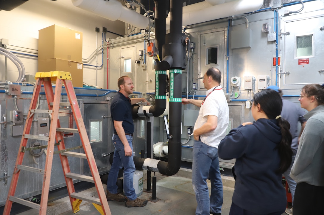 Practicum instructors Robert Renz, research mechanical engineer (left) and Ryan Stroupe, research civil engineer, at the U.S. Army Engineer Research and Development Center’s Construction Engineer Research Laboratory (ERDC-CERL), lead a session in the Dedicated Outdoor Air System at ERDC-CERL.